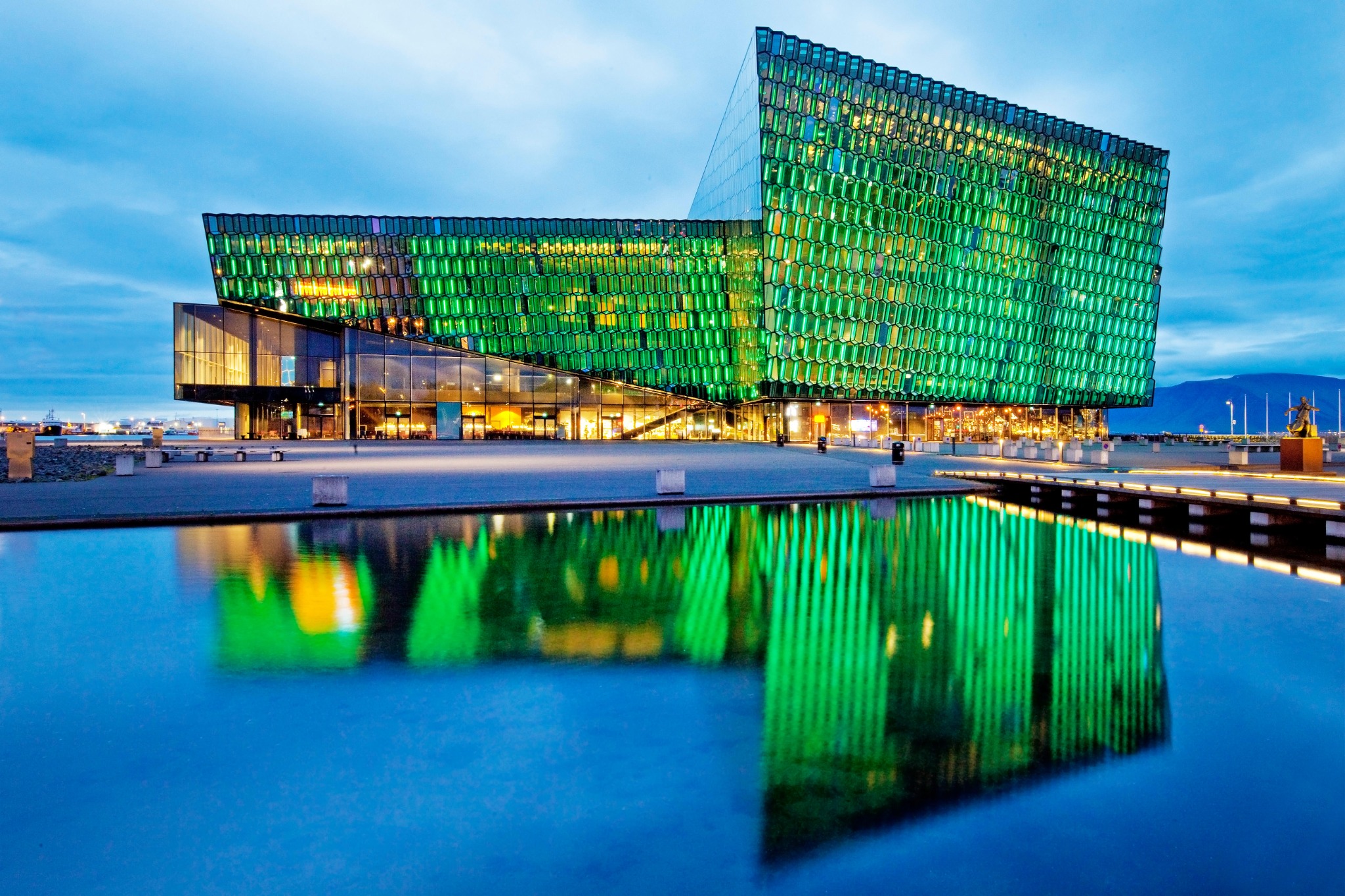 Die beleuchtete Harpa-Konzerthalle mit ihrer Spiegelung im Wasser